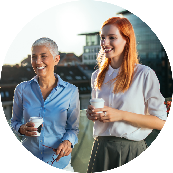 two women holding paper cups and smiling